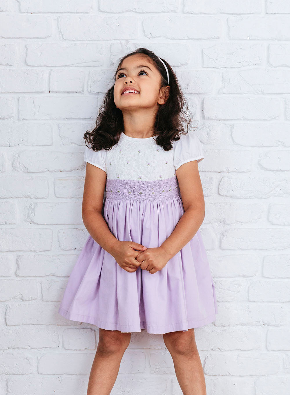 Children's dress of lilac cotton printed in strips of burgundy and white  motifs, frock outerwear children's clothing clothing cotton, textile sewn  (hand) smocked pleated wrinkled Girls dress of lilac cotton with print